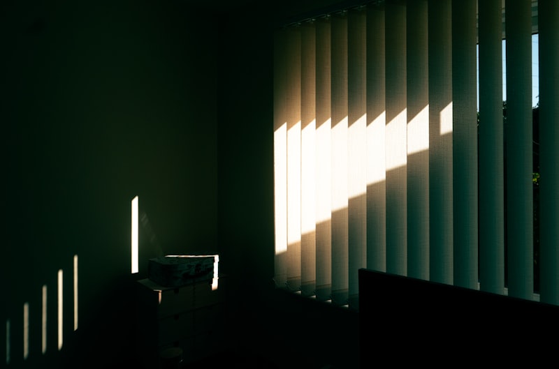Sunlight streaming through roller blinds in a room